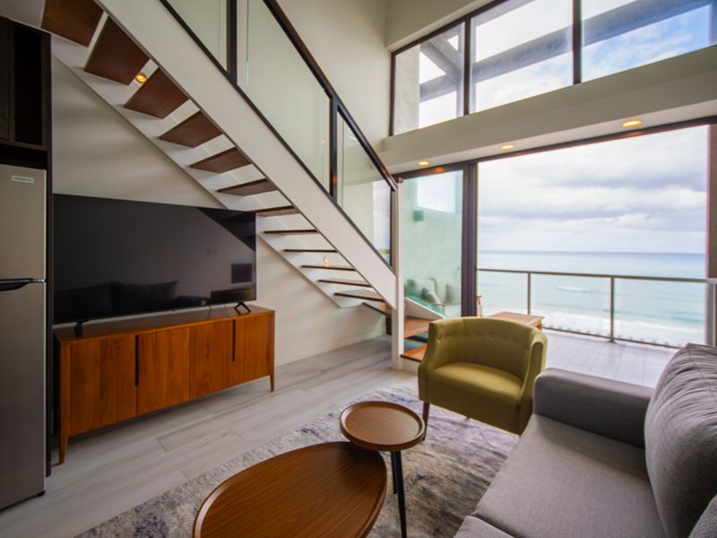 Living room and staircase in Bessa’s three-bedroom ocean loft